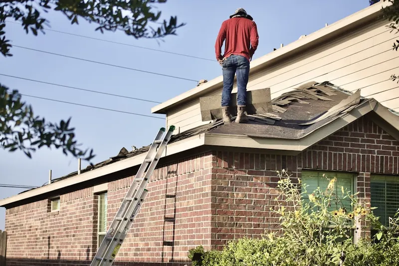 Professional roofer working on a residential roof in Leawood